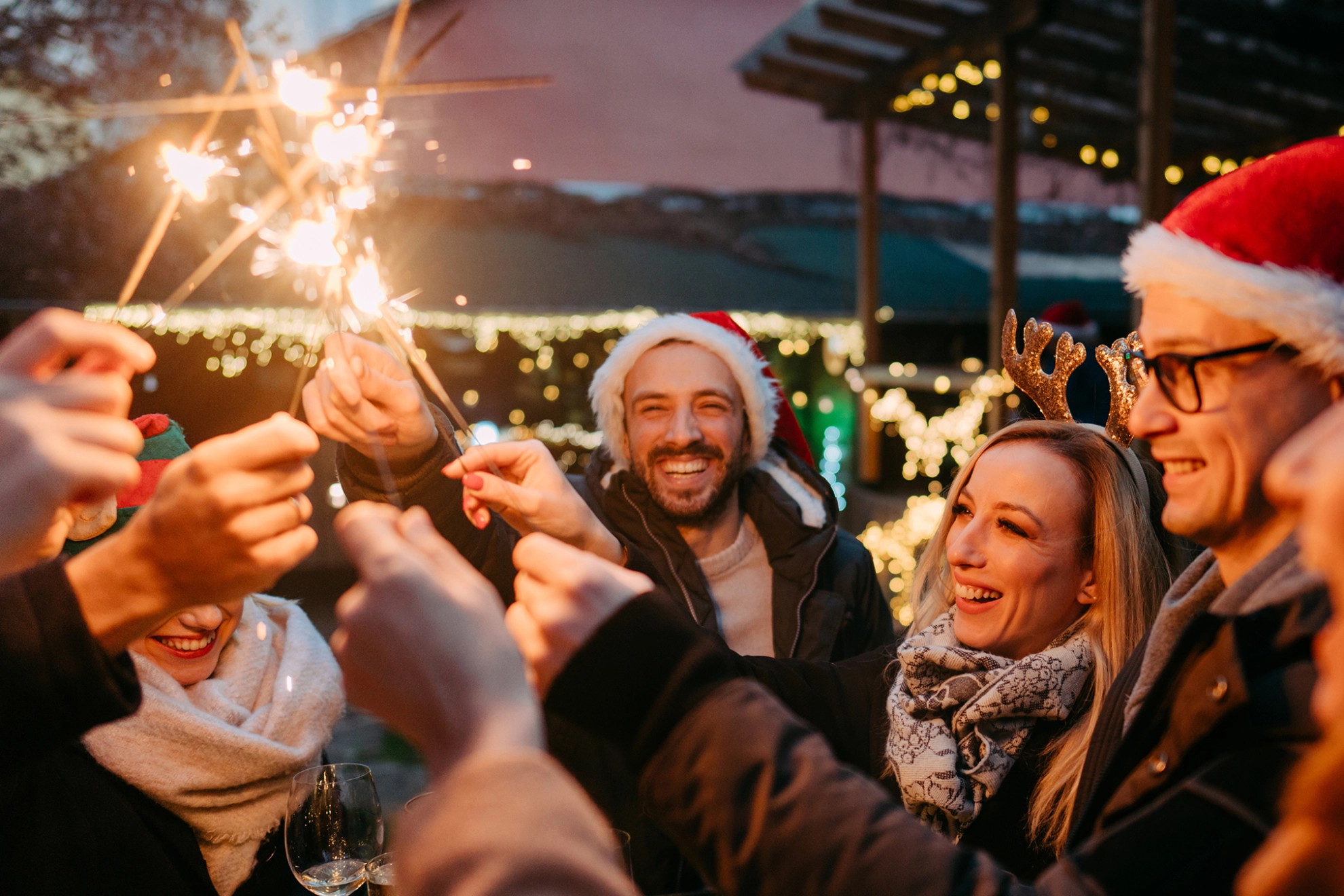 Mehrere Menschen feiern ausgelassen auf einem Weihnachtsmarkt.